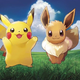 Pikachu and Eevee in a field smiling